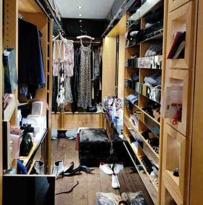 A cluttered walk-in wardrobe