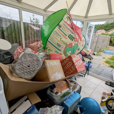 A cluttered conservatory before organising